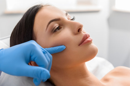 Skin specialist examining patient skin for treatment